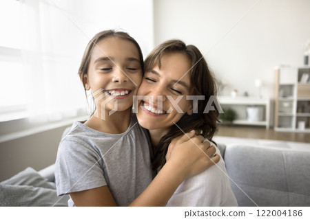 Close up faces cheerful beautiful mother and little daughter hugging 122004186
