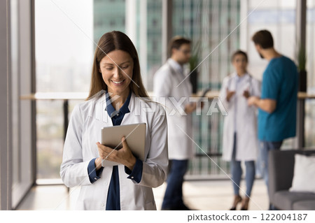 Female doctor working online using tablet device Female doctor working online using tablet device 122004187