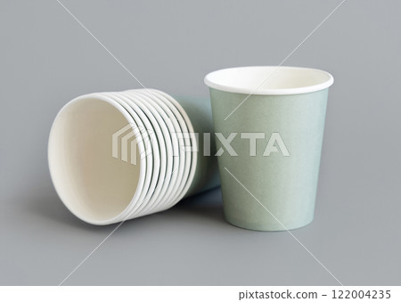 Light green paper disposable cup closeup on grey. Eco friendly, zero plastic tableware Light green paper disposable cup closeup on grey. Eco friendly, zero plastic tableware 122004235