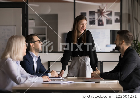 Laughing businesspeople take part in briefing with teammates Laughing businesspeople take part in briefing with teammates 122004251