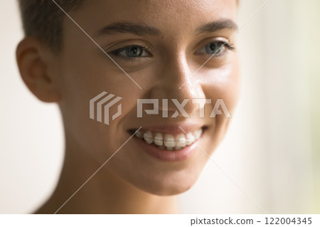 Close up cropped shot beautiful smiling millennial European female face 122004345