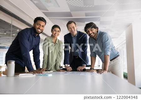 Multiethnic team of ambitious young colleagues standing at workplace 122004348
