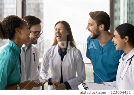 Happy clinic staff members laughing gathered together in clinic office 122004451