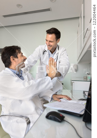 Two cheerful practitioner doctor making high five gesture Two cheerful practitioner doctor making high five gesture 122004464