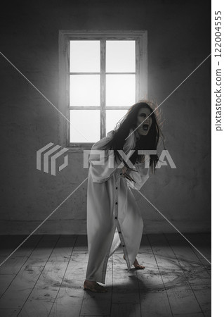 Inner fear and hysteria. A dynamic image of a creepy shouting woman with pale face, black hair, in a long white gown screaming Inner fear and hysteria. A dynamic image of a creepy shouting woman with pale face, black hair, in a long white gown screaming 122004555
