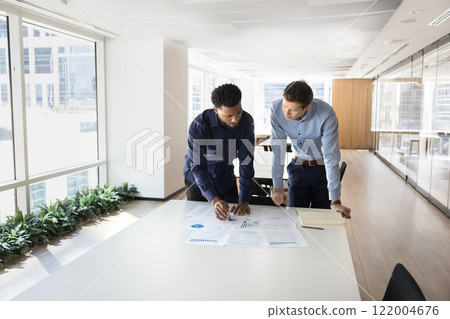 Focused busy multiethnic male professionals working on project 122004676