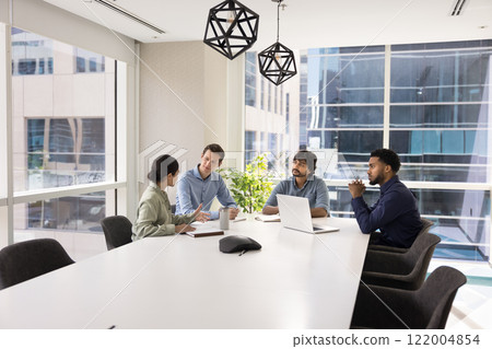 Diverse group of professional colleagues talking at large white table Diverse group of professional colleagues talking at large white table 122004854