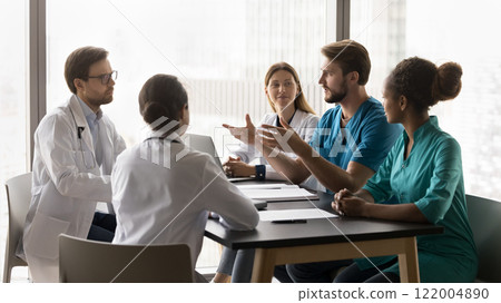 Young doctor make speech during briefing with diverse clinic workmates 122004890