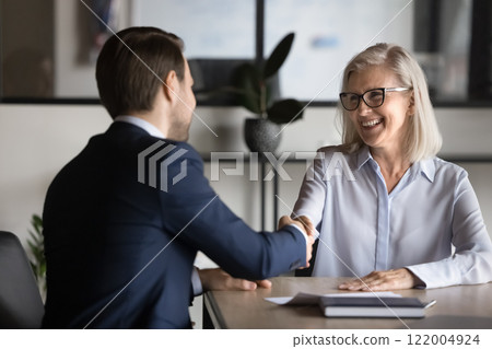 Two European business partners shake hands met in office Two European business partners shake hands met in office 122004924