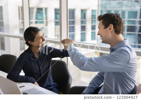 Cheerful office coworkers making fist bump friends gesture 122004927