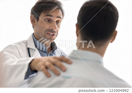 Serious middle aged Latin medical specialist encouraging patient for win 122004992