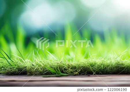 Close up of young green grass growing in soil over blurred nature background Close up of young green grass growing in soil over blurred nature background 122006190