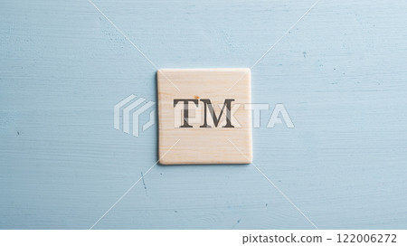 Wooden tile with TM sign on it 122006272