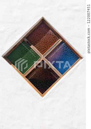 rhombus shape stained glass window is embedded in gray wall rough 122007451