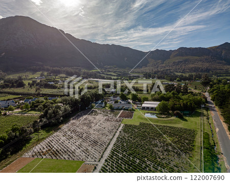 Rural landscape with majestic mountain range. estate, several structures Rural landscape with majestic mountain range. estate, several structures 122007690