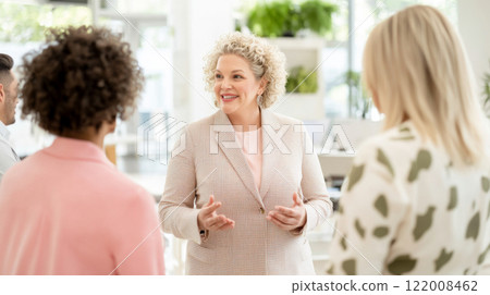 Business meeting with diverse group of women discussing ideas in bright office, gender equality concept 122008462