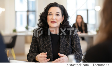 Business meeting with diverse group of women discussing ideas in bright office, gender equality concept 122008463