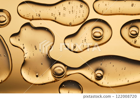 The beautiful texture of the cosmetic serum on a gold background that takes up most of the photo. 122008720