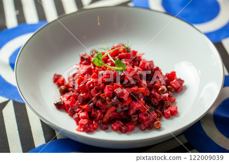 Traditional Russian vinegret salad featuring vibrant vegetables and peas, beautifully presented on a crisp white plate Traditional Russian vinegret salad featuring vibrant vegetables and peas, beautifully presented on a crisp white plate 122009039