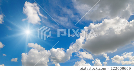 Blue sky with white clouds and bright sun. 122009669