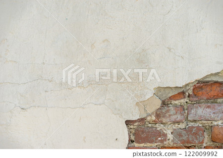Aged Wall With Exposed Red Bricks and Cracked Plaster Surface 122009992