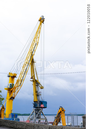 port cranes, industrial harbor cranes for sea port with a stabilizer and a hook against a blue sky. High quality photo 122010058