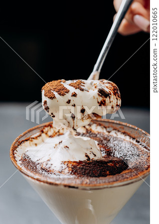 Decadent espresso martini topped with whipped cream and cocoa, served in a martini glass 122010665