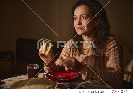 Woman enjoying pancakes during Shrove Tuesday celebration at home Woman enjoying pancakes during Shrove Tuesday celebration at home 122010741