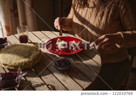 Woman Enjoys Breakfast Including Crepes and Jam on a Sunny Morning Woman Enjoys Breakfast Including Crepes and Jam on a Sunny Morning 122010768