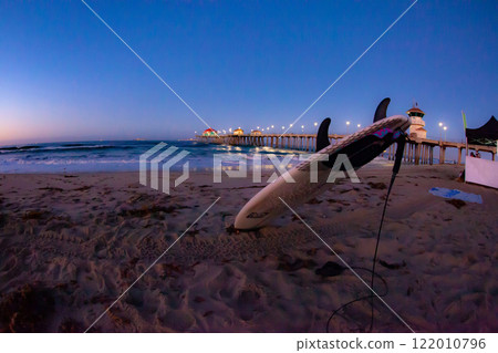 Dawn at the Huntington Beach Pier with a Surfboard in the Sand 122010796