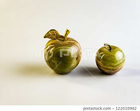 Two Souvenirs Apples made of onyx with a golden stalk on a white background. 122010982