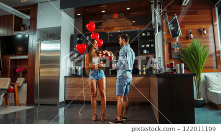 A man giving a woman a bouquet of flowers in a kitchen 122011109