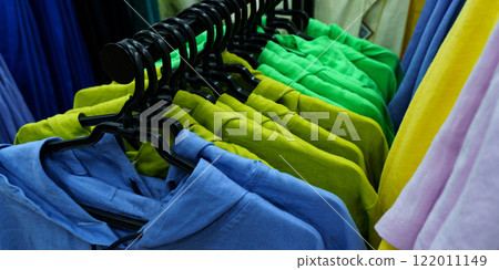 Colorful display of casual shirts hanging in a vibrant retail store setting 122011149