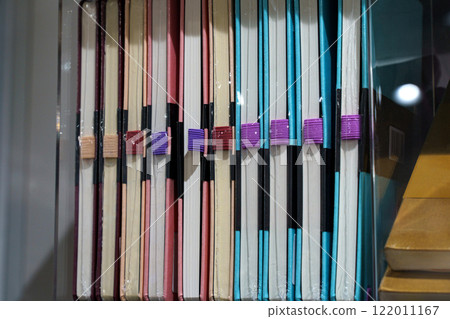 Colorful collection of notebooks displayed on shelves in a cozy bookstore 122011167
