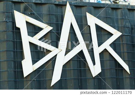 Wooden letters spell out bar at a stylish outdoor venue in the afternoon 122011170