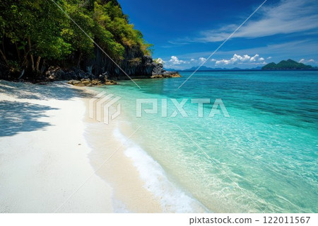 Scenic tropical beach with crystal clear blue waters and white sandy shores. 122011567