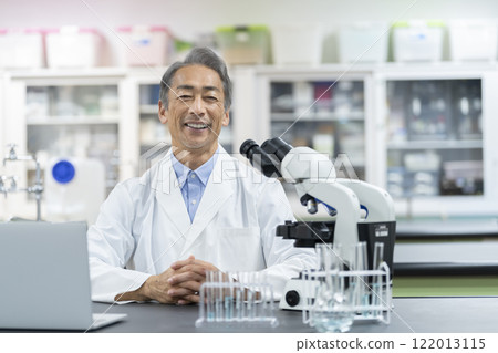 Researcher/scientist image: A man in his 60s wearing a white coat, looking at the camera, portrait 122013115