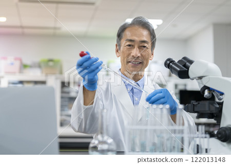 一位資深研究人員看著相機進行實驗的肖像 一位資深研究人員看著相機進行實驗的肖像 122013148