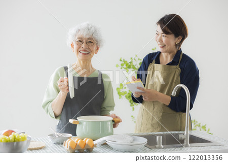 Grey-haired woman standing in the kitchen Grey-haired woman standing in the kitchen 122013356