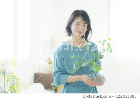 Woman holding a vase in the living room 122013395