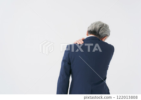 Senior man in a suit rubbing his shoulder Senior man in a suit rubbing his shoulder 122013808