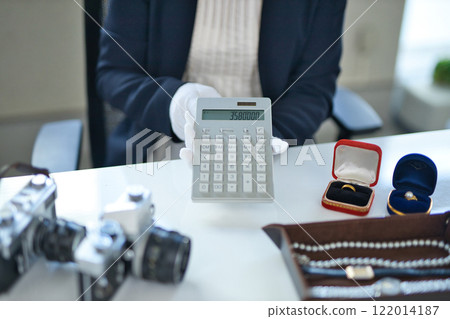 The hands of a specialist buyer assessing precious metals The hands of a specialist buyer assessing precious metals 122014187