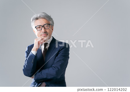 Senior man in a suit sitting on a chair Senior man in a suit sitting on a chair 122014202