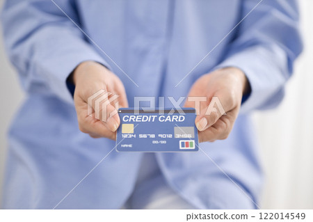 Middle-aged woman handing over a credit card 122014549