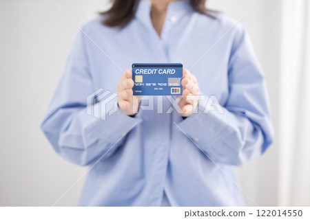 Middle-aged woman handing over a credit card Middle-aged woman handing over a credit card 122014550