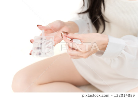 年輕女子拿著補充劑盒,抓著藥丸零件被切開 年輕女子拿著補充劑盒,抓著藥丸零件被切開 122014889