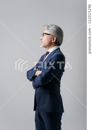 A businessman standing with his arms folded 122015296