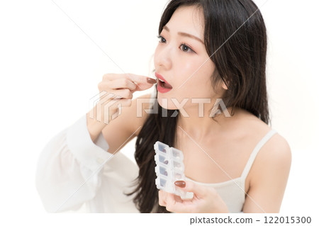 一名年輕女子喝酒補充劑 一名年輕女子喝酒補充劑 122015300