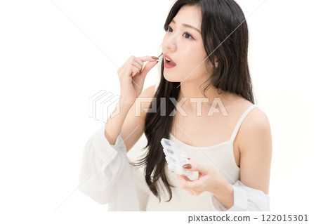 一名年輕女子喝酒補充劑 一名年輕女子喝酒補充劑 122015301