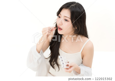 A young woman drinking supplements 122015302
